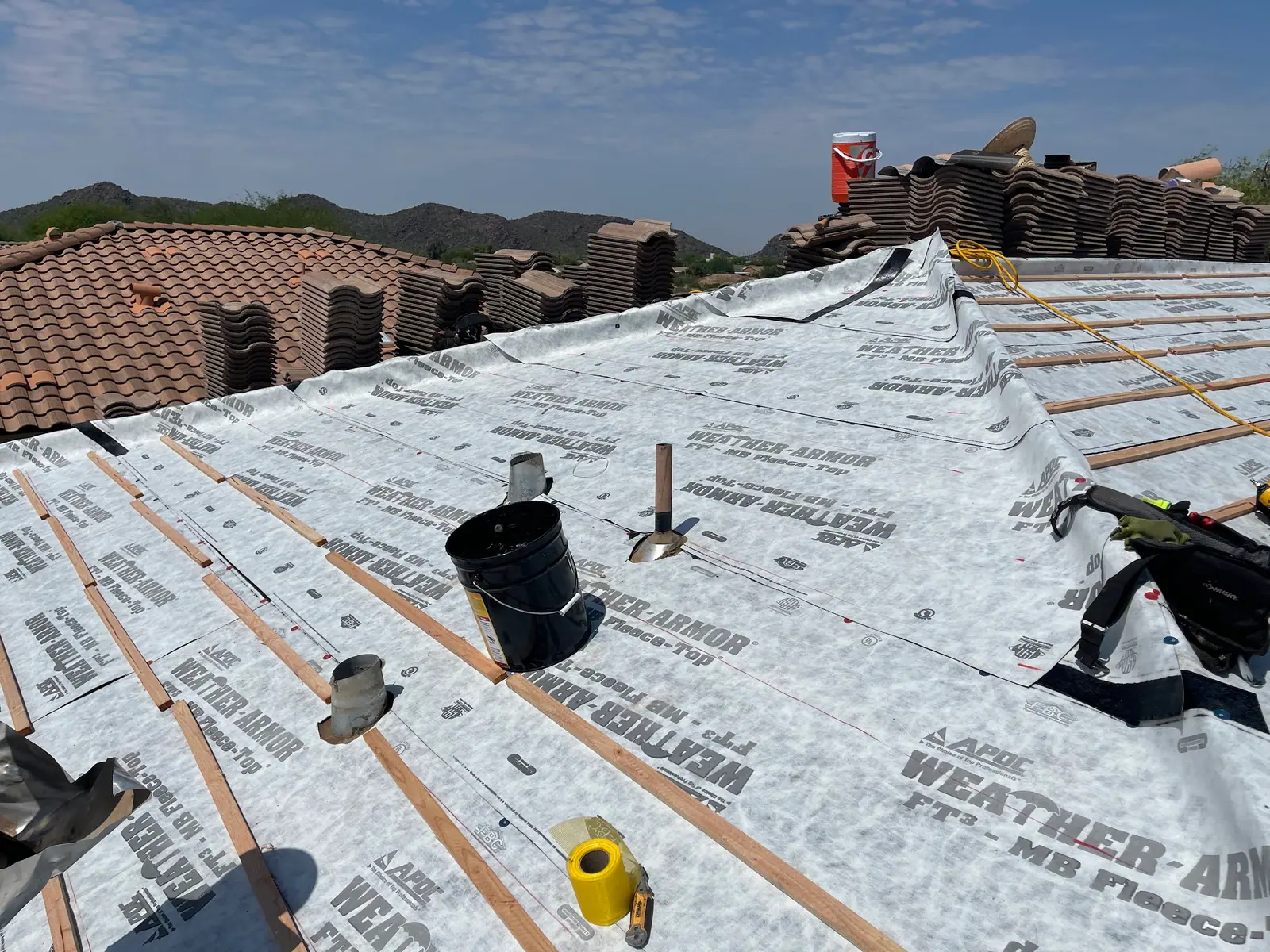 Tile removed and new underlayment rolled out on a pitched roof